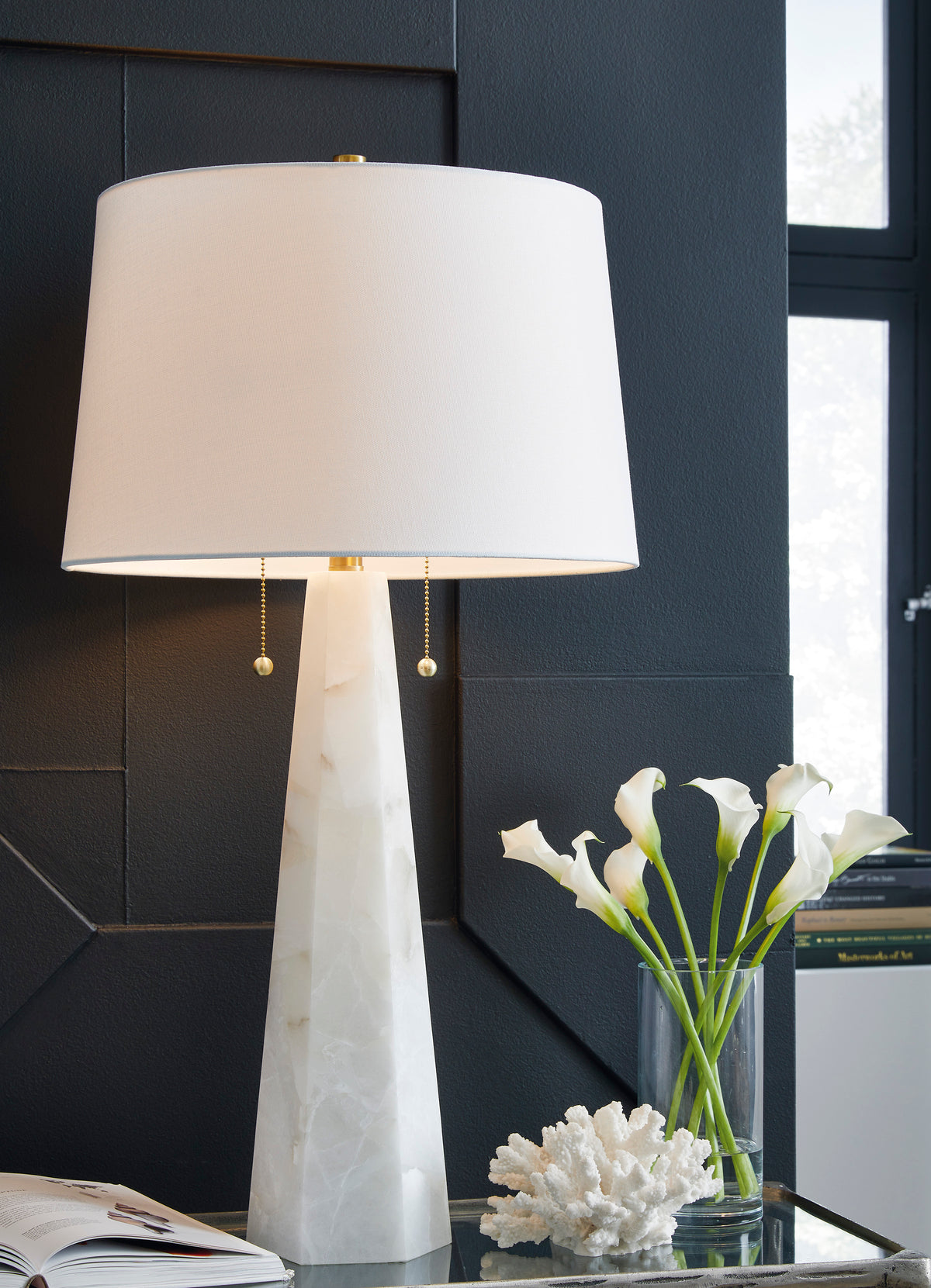 Alabaster table lamp with white fabric shade and fluted stone base