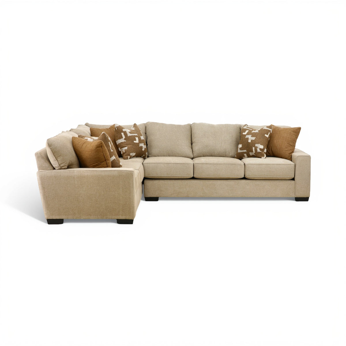 Beige sectional sofa with chaise end and patterned throw pillows on the back cushions