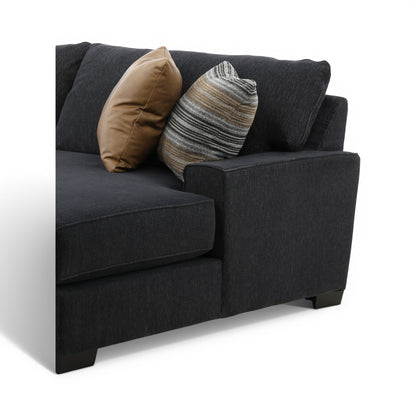Dark charcoal sectional chaise with tan and gray striped throw pillows on the seat cushion