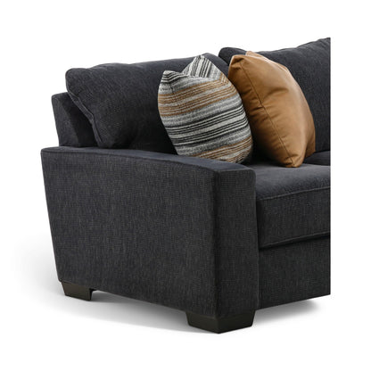 Corner section of dark charcoal sectional chaise, showing upholstered arm and mixed accent pillows