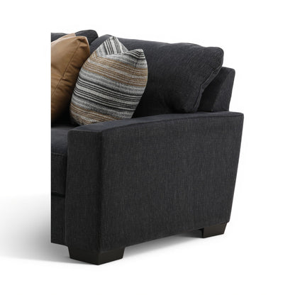 Charcoal fabric armchair chaise section with striped and tan pillows