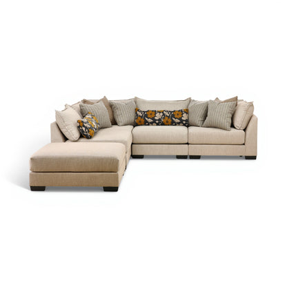 Beige modular sectional sofa with chaise, cushioned ottoman, and patterned throw pillows