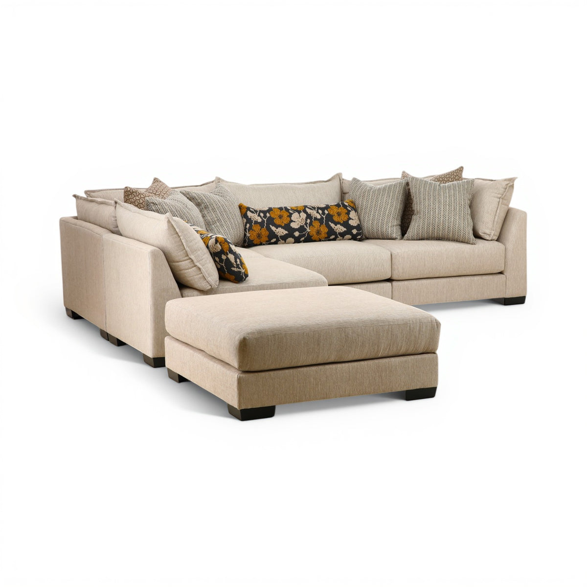 Beige modular sectional sofa with chaise, tufted cushions, and patterned accent pillows