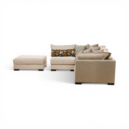 Beige modular sectional sofa with separate ottoman pieces and patterned pillow accents