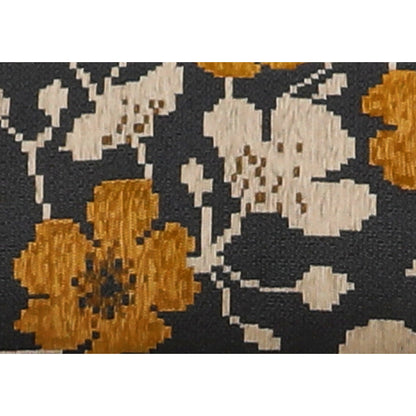 Close-up of black, white, and gold floral patterned throw fabric