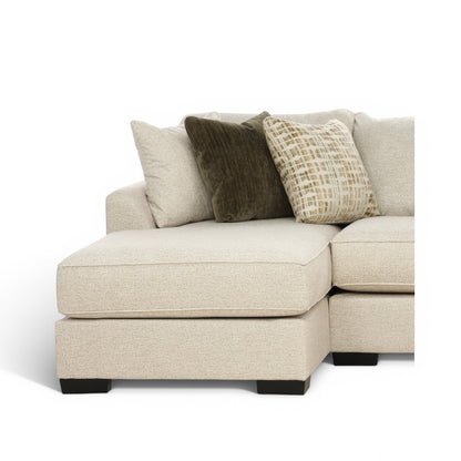Sectional chaise corner with light beige seat, dark and patterned accent pillows