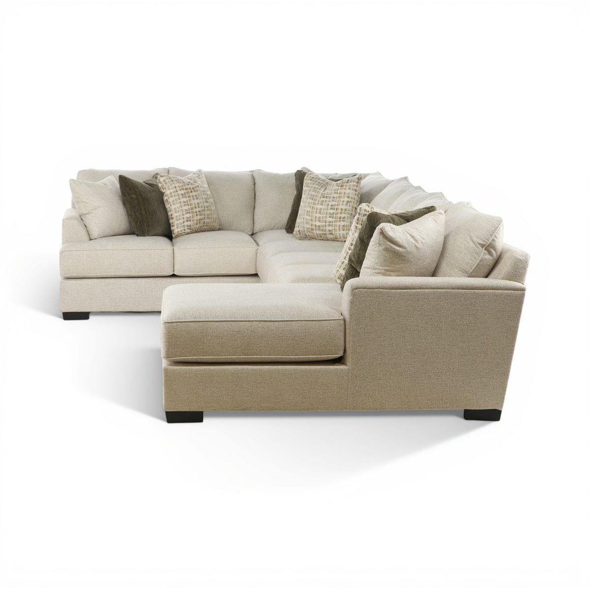 Three-piece sectional sofa with chaise lounge, beige seat cushions and draped pillows