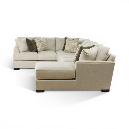 Three-piece sectional sofa with chaise lounge, beige seat cushions and draped pillows