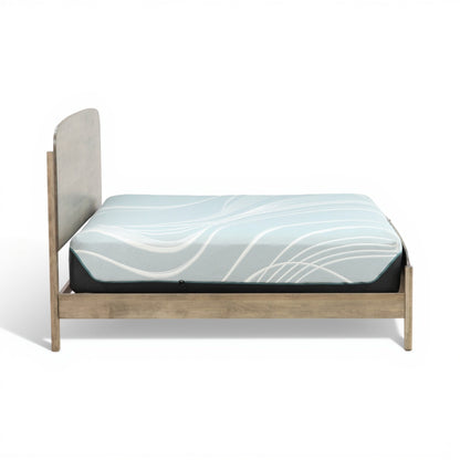 Platform bed with gray-wash frame and blue patterned comforter, side view