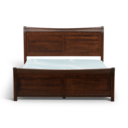 Brown sleigh bed frame with paneled headboard and blue patterned mattress