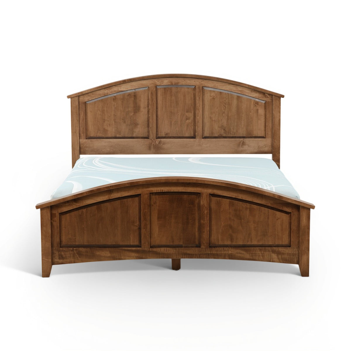 Wood bed with arched headboard and three-panel footboard, styled with light-blue bedding