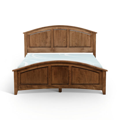 Wood bed with arched headboard and three-panel footboard, styled with light-blue bedding