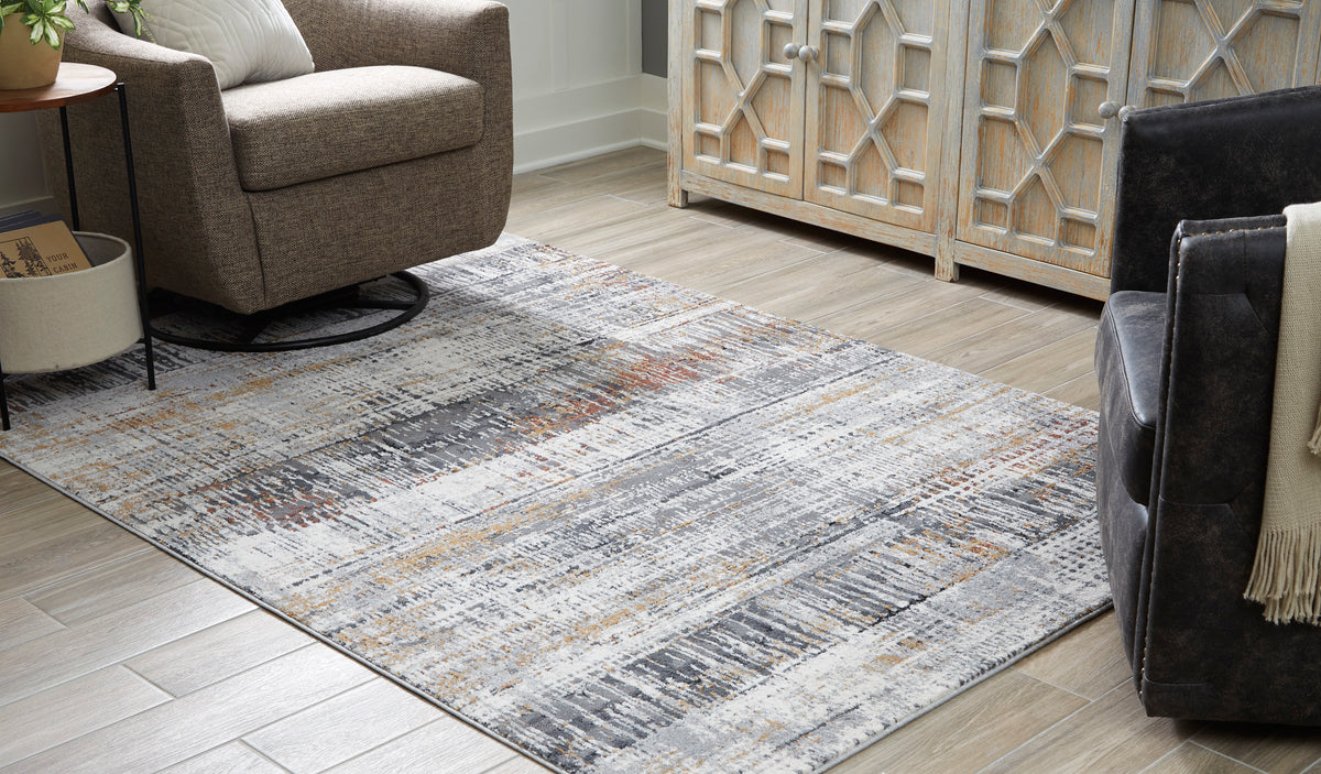 Light gray area rug with distressed abstract lines and speckled orange, black, and beige