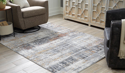 Light gray area rug with distressed abstract lines and speckled orange, black, and beige