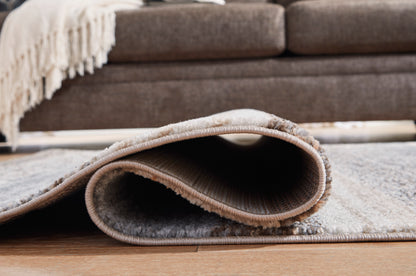 Ashley Sethburn rug corner close-up with stitched border and layered abstract pattern