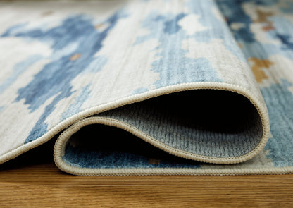Blue and white abstract rug with stitched border, close-up pile edge