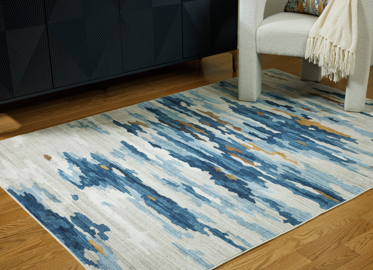 Abstract blue and white washable rug with distressed cloud-like pattern