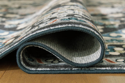 Washable rug edge close-up with dark teal binding and patterned pile