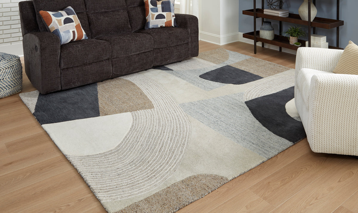 Geometric area rug with cream, gray, black, and tan blocks and circular pattern