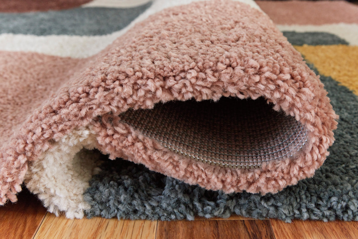 Folded geometric area rug showing plush loop pile and textured underside