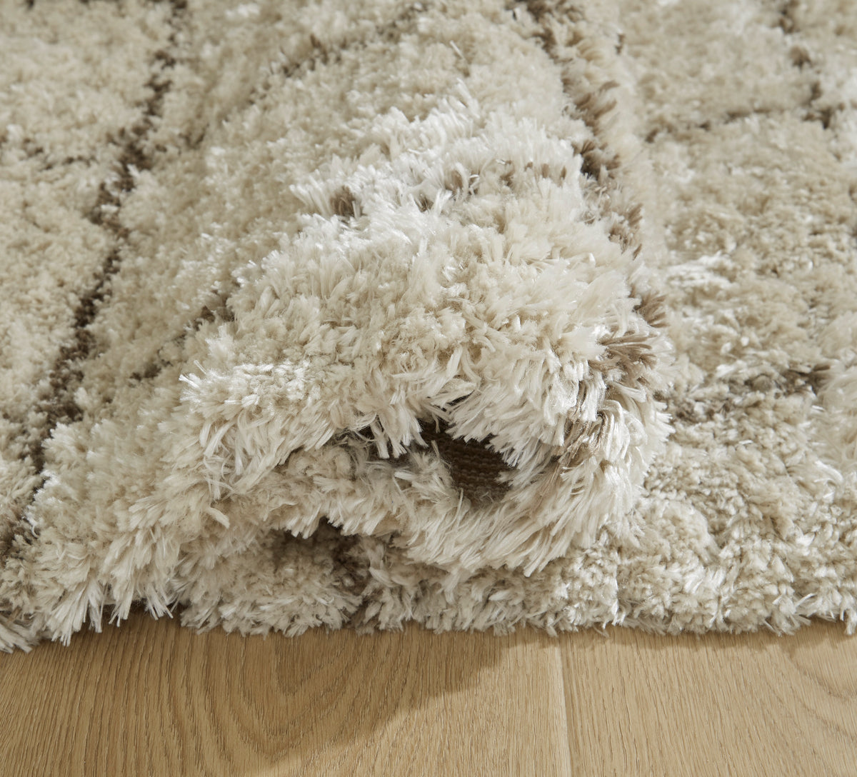 Cream shag rug with dense long pile texture, close-up view