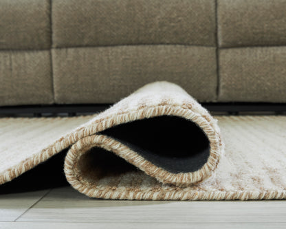 Cream rug with low pile, textured weave, and stitched edge showing underside