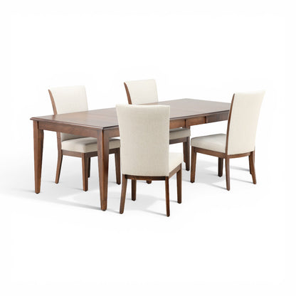 Corner view of five-piece dining set: wooden table and four cream upholstered chairs