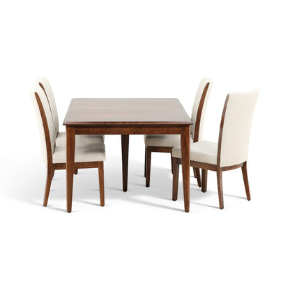 Wood dining table with four beige upholstered chairs in an upright arrangement