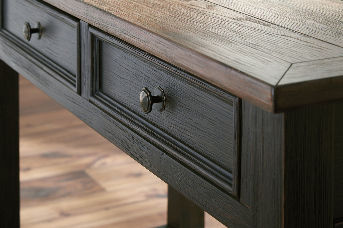 Close-up of dark wood drawer front with metal pull hardware on sofa table