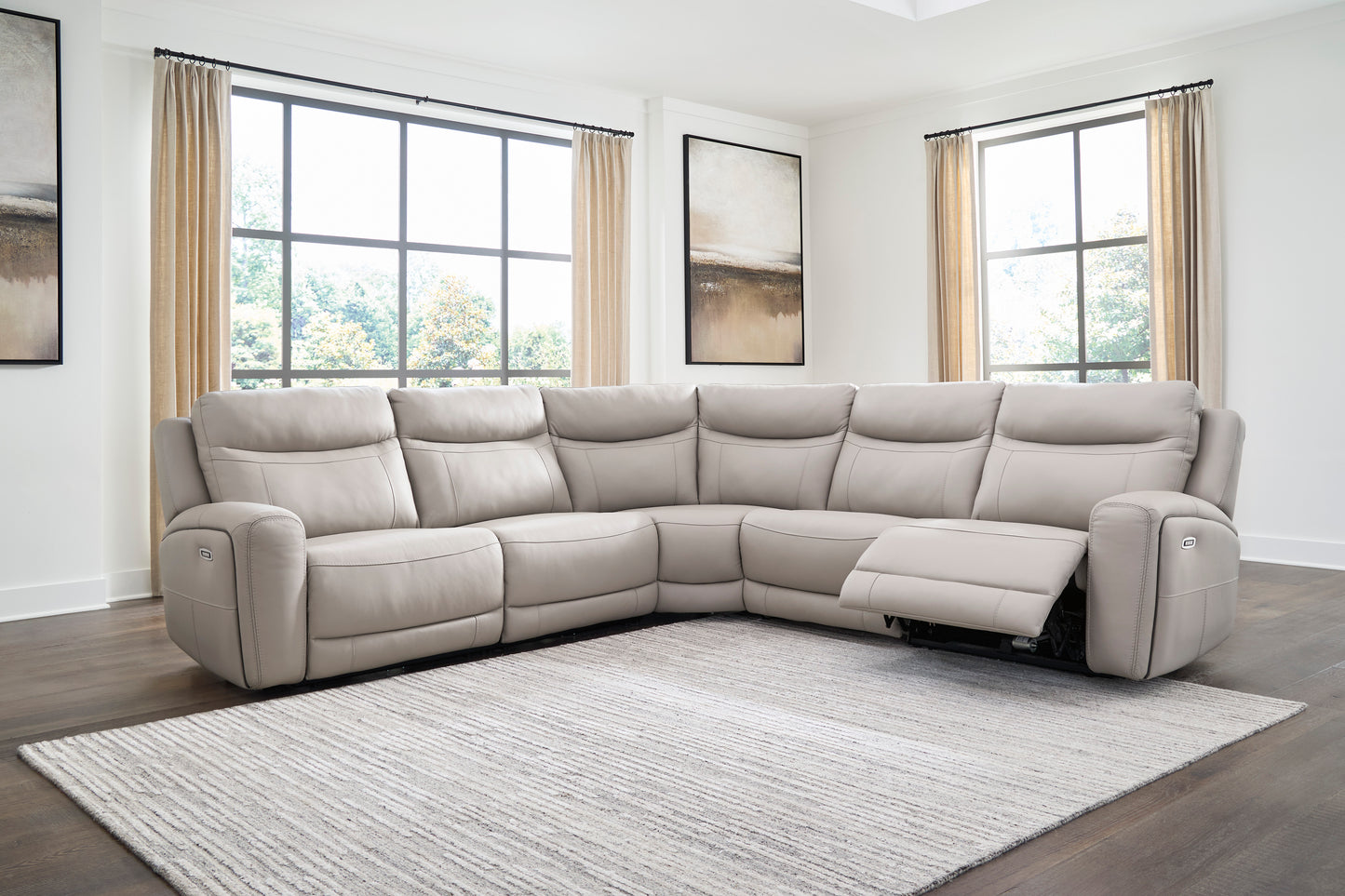 Light gray sectional sofa with power recline, extended footrests, and control switches on arms