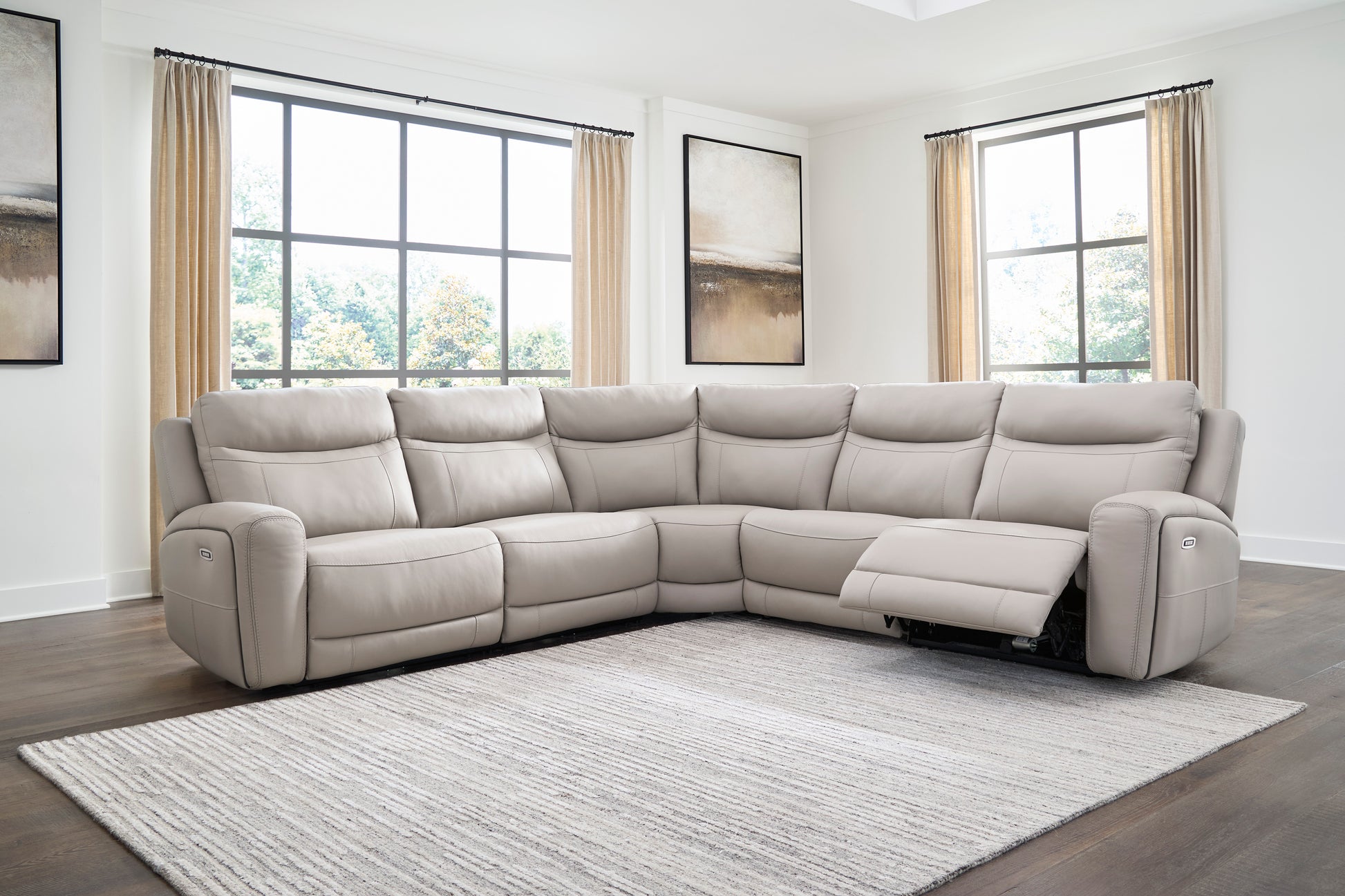 Light gray sectional sofa with power recline, extended footrests, and control switches on arms