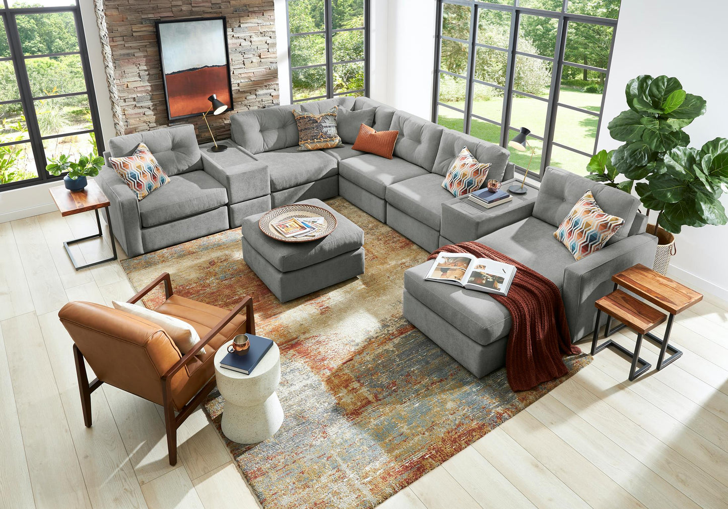 Gray modular sectional sofa with patterned throw pillows and corner chaise ottoman seating