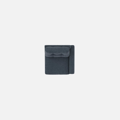 Upholstered armchair in dark navy, close view of backrest with tufted cushioning