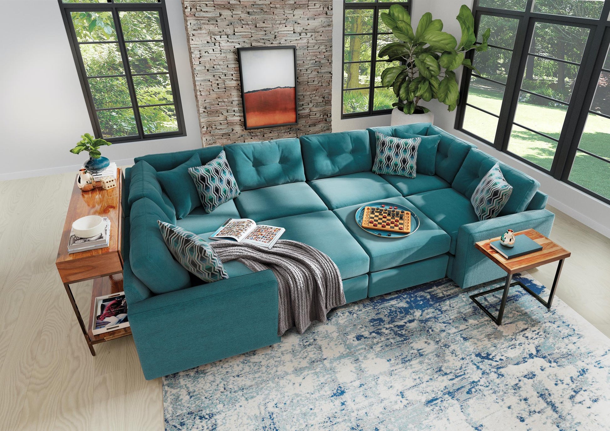 Teal modular sectional sofa with patterned pillows, draped blanket, and corner chaise