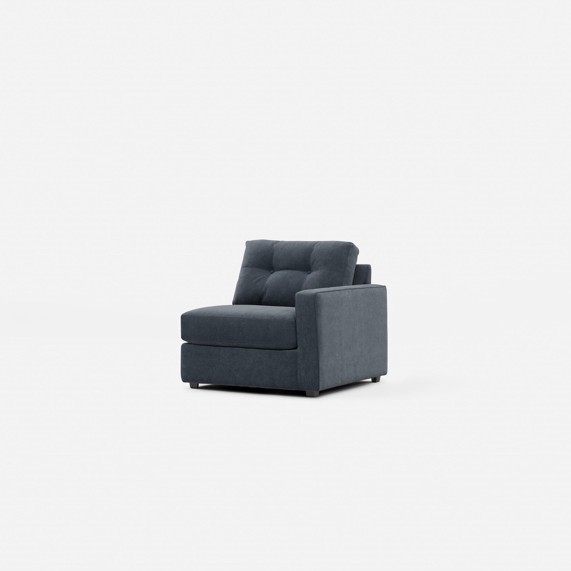 Upholstered armchair in dark navy, side view with tufted back and cushioned seat