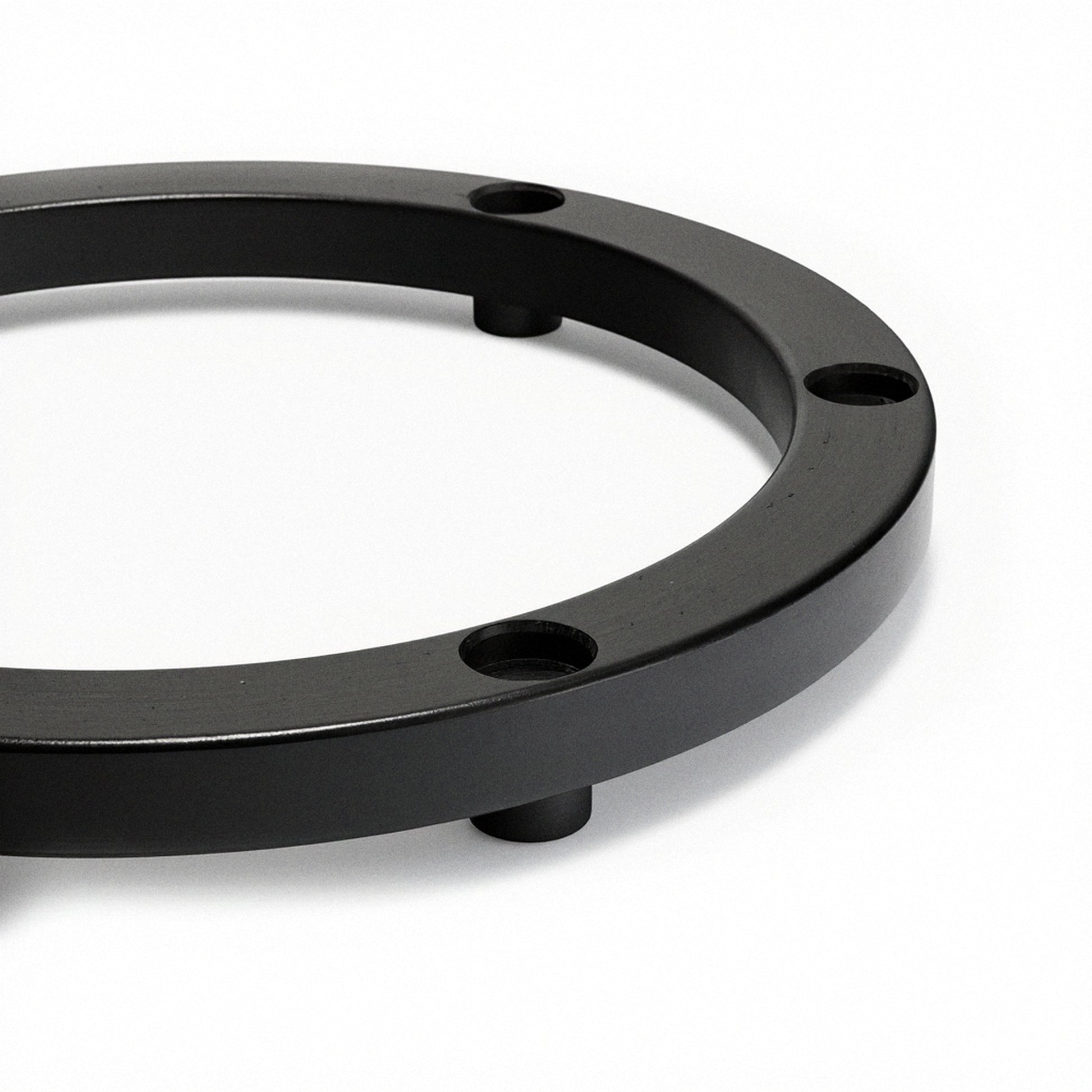 Black elevator ring base with curved rim and three visible feet