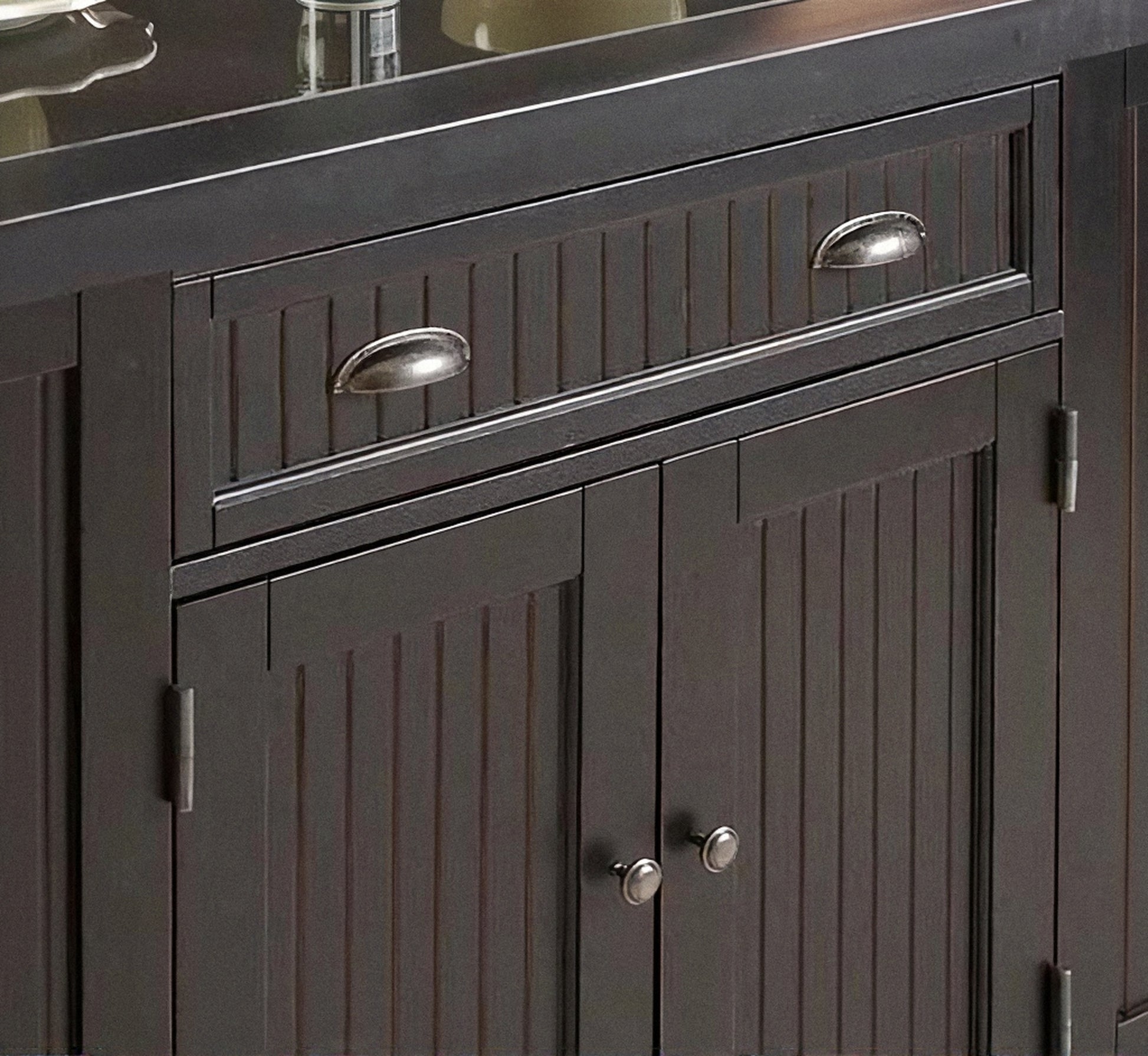 Dark kitchen island cabinet with paneled doors, drawers, and silver metal handles